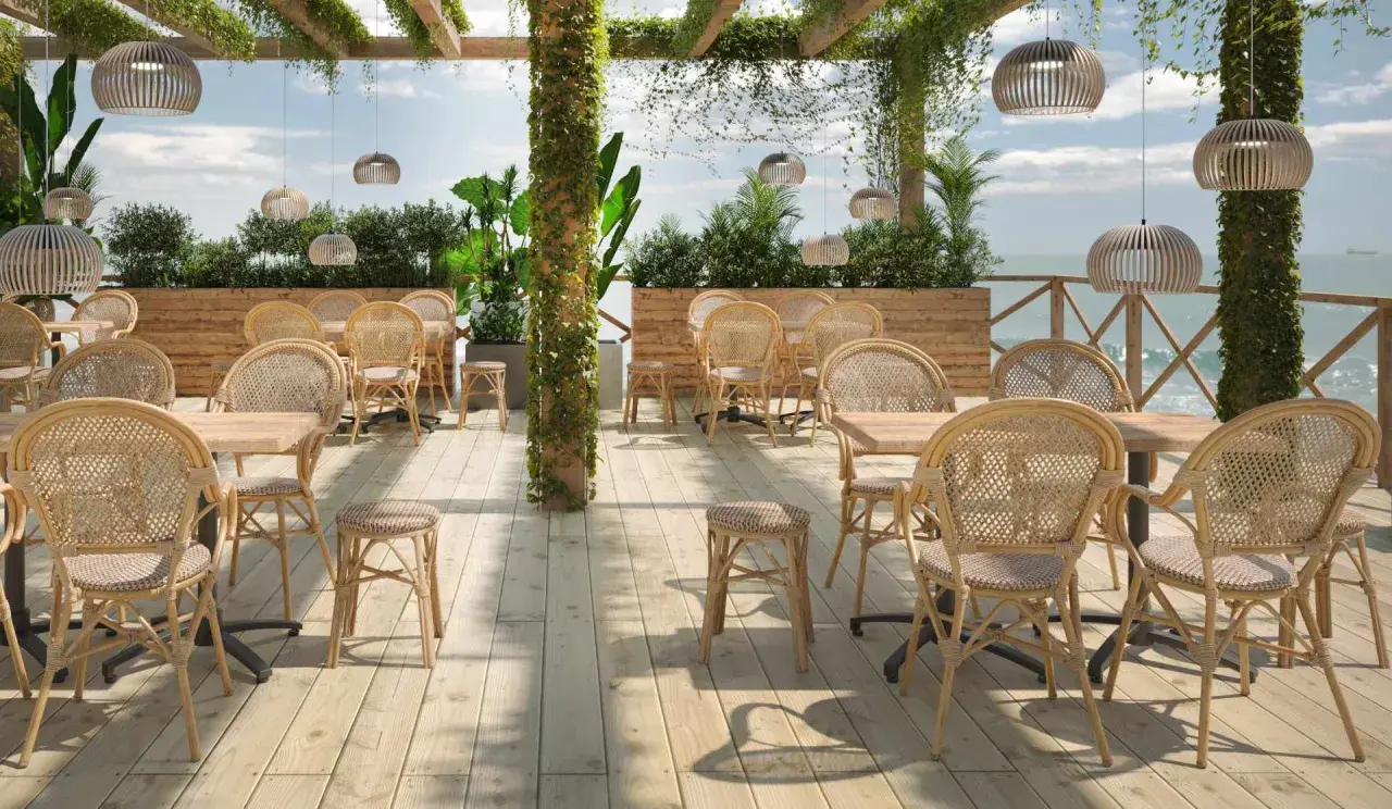 Terrasse mit Rattanmöbeln und Blick aufs Meer.